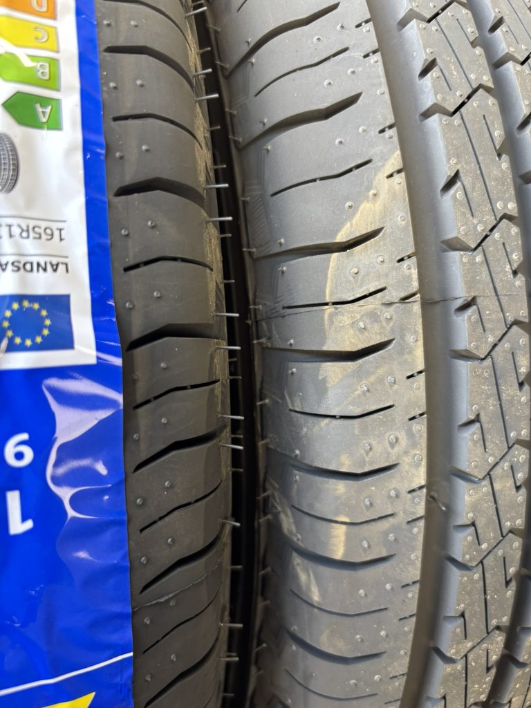 Two car tires with the little vent spews sticking out of the sides